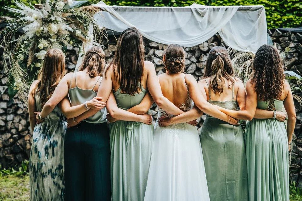 Braut mit Brautjungfern Arm in Arm